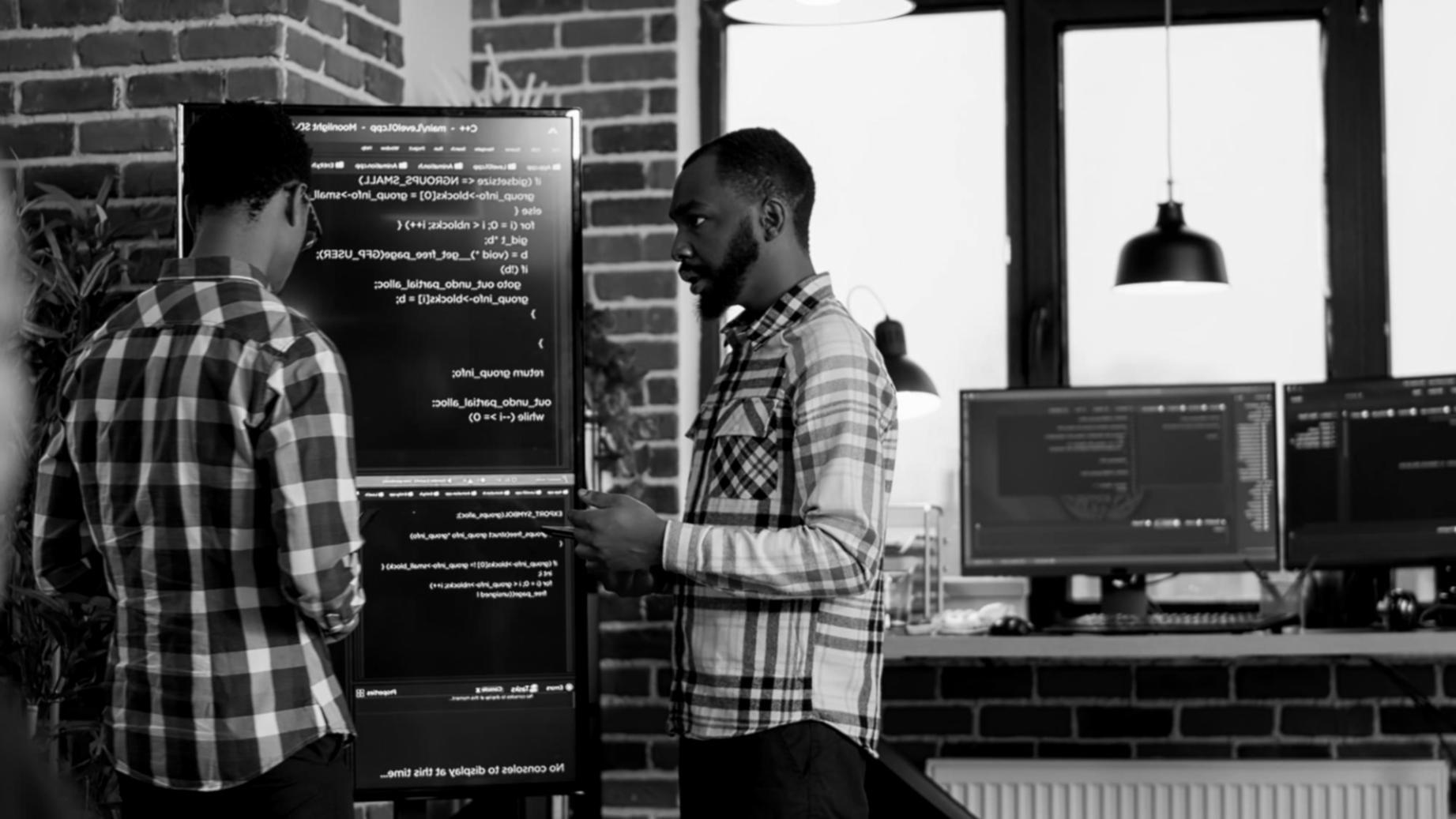 Software testing workspace with multiple monitors displaying test results and debugging interfaces